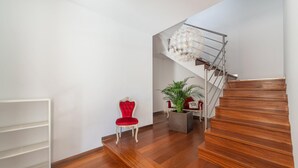 A staircase with wooden steps leading to a landing with a white metal shelf and a red chair. - Can Joan (maria) - Apartment With Private Pool (, Illes Balears)