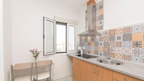 A compact kitchen with a window, a sink, and a dining area with a table and chairs.