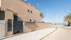 A building with a flat facade, a gated entrance, and a clear sky.