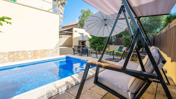 A swimming pool with lounge chairs and a pergola.