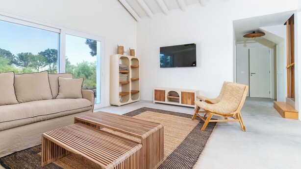 A modern living room with a sofa, a coffee table, a TV, and a chair. - La Réserve Comporta (Grandola)