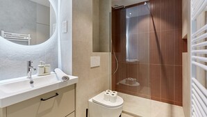 A modern bathroom with a sink, toilet, and shower.