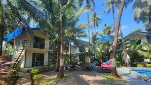 A resort with a pool, lounge chairs, and palm trees. - La Perla Resort By Circle Hotels&Resort (Morjim)