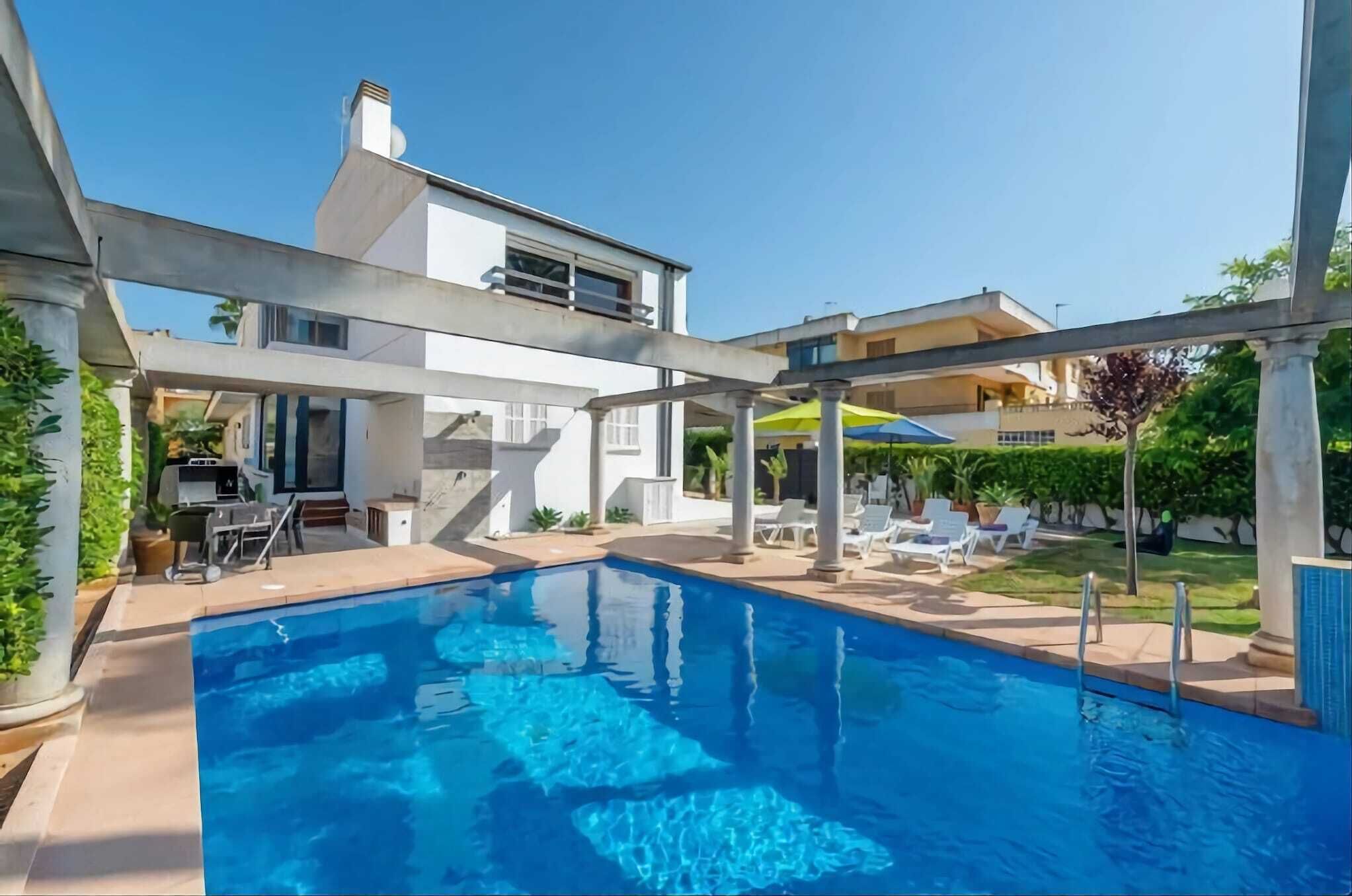 Une maison moderne dotée d’une piscine, de mobilier d’extérieur et d’un espace patio.