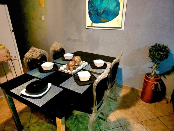 Une table à manger avec des sets de table noirs, des bols blancs et des objets décoratifs.
