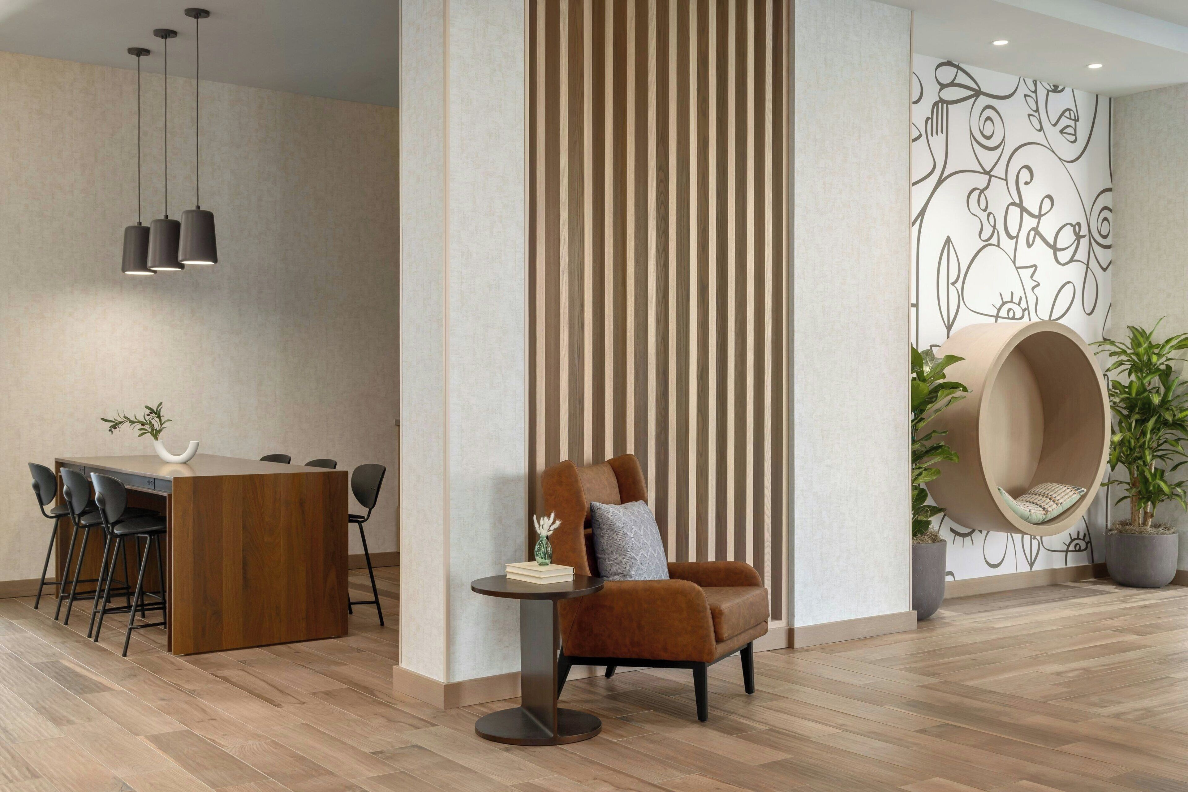 A modern dining area with a wooden table, chairs, and pendant lighting.