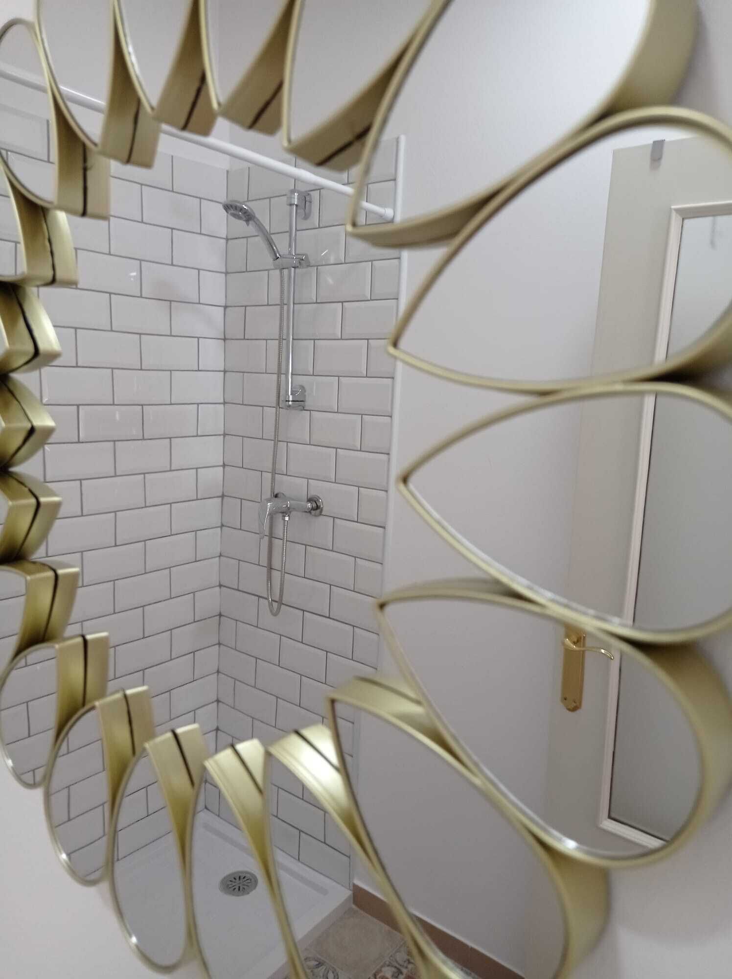 Un baño con paredes de azulejos blancos, una ducha y un inodoro.