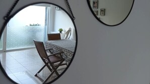 Zwei ovale Spiegel mit Kette hängen an einer weißen Wand.