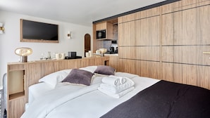 Ein modernes Hotelzimmer mit einem Bett, einem Schreibtisch, einem Flachbildfernseher, einer Mikrowelle und einem Kleiderschrank.
