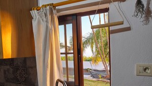 A kitchen with a stainless steel sink, a window with a view of palm trees, and a wooden ceiling. - Apartment Padres A for 4 people (Santa Cruz de Tenerife)