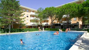 Une piscine entourée d’immeubles d’appartements dotés de balcons.