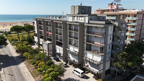 Ein mehrstöckiges Hotel mit Balkonen in Strandnähe.