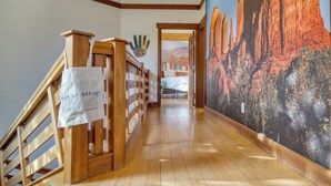 A wooden staircase with a 'Out of Office' sign, a mural of a desert landscape, and a wooden floor. - Scenic Views with Pool Table & Hot Tub | Cathedral View by AvantStay (Sedona)