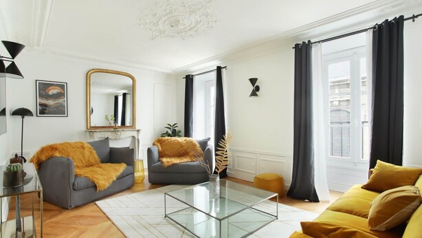 A living room with a glass coffee table, two sofas, a mirror, and a view of the outside. - Sublime Apartment With AC Louvre Museum (Paris)
