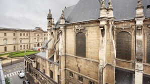 A historic building with a prominent tower and arched windows. - Sublime Apartment With AC Louvre Museum (Paris)