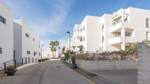 Een moderne straat met woonhuizen, een geplaveid wegdek en een gele markering.
