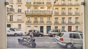 A street view with parked cars and a motorbike. - WS - Opéra - Milan (Paris)