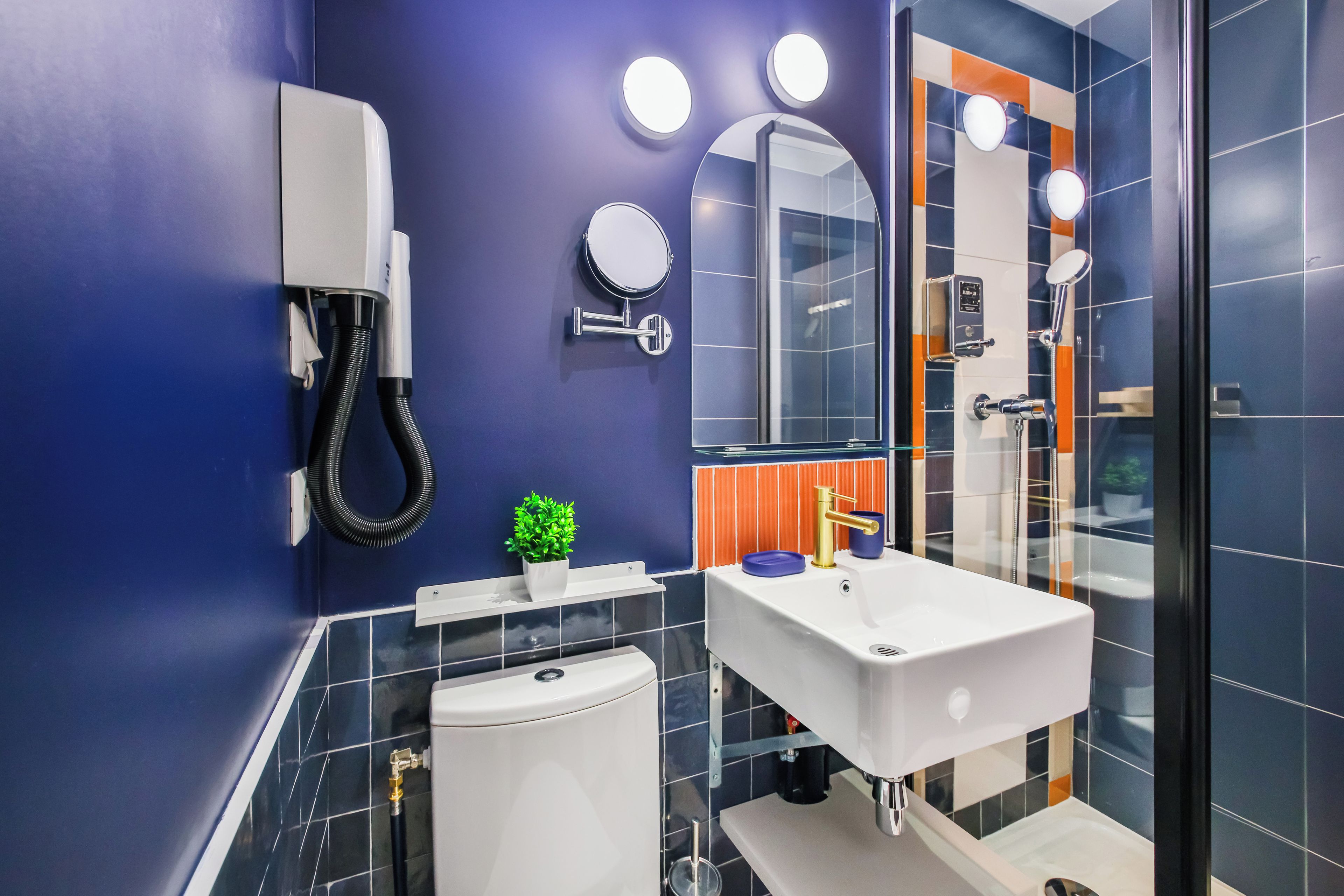 A modern bathroom with a white sink, a mirror, and a toilet.