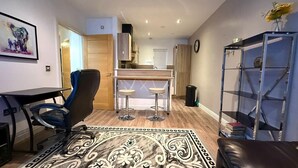 A compact living space with a dining area, a kitchen, and a bar area. - Cosy City Centre Apartment with parking (West Midlands)
