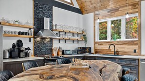 Una cocina moderna con una isla grande, electrodomésticos integrados y una pared de acento de piedra.