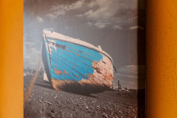 A boat with peeling blue paint on a dock.