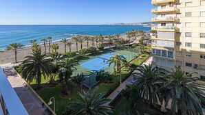 A tennis court surrounded by palm trees, with a view of the beach and ocean. - Algarrobo Costa - Apartment In Algarrobo-costa (Algarrobo Costa, Málaga)