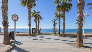 A paved promenade with palm trees, a beach, and a no bicycle sign. - Algarrobo Costa - Apartment In Algarrobo-costa (Algarrobo Costa, Málaga)