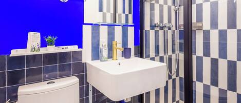 A modern bathroom with a white toilet, a sink, and a shower.