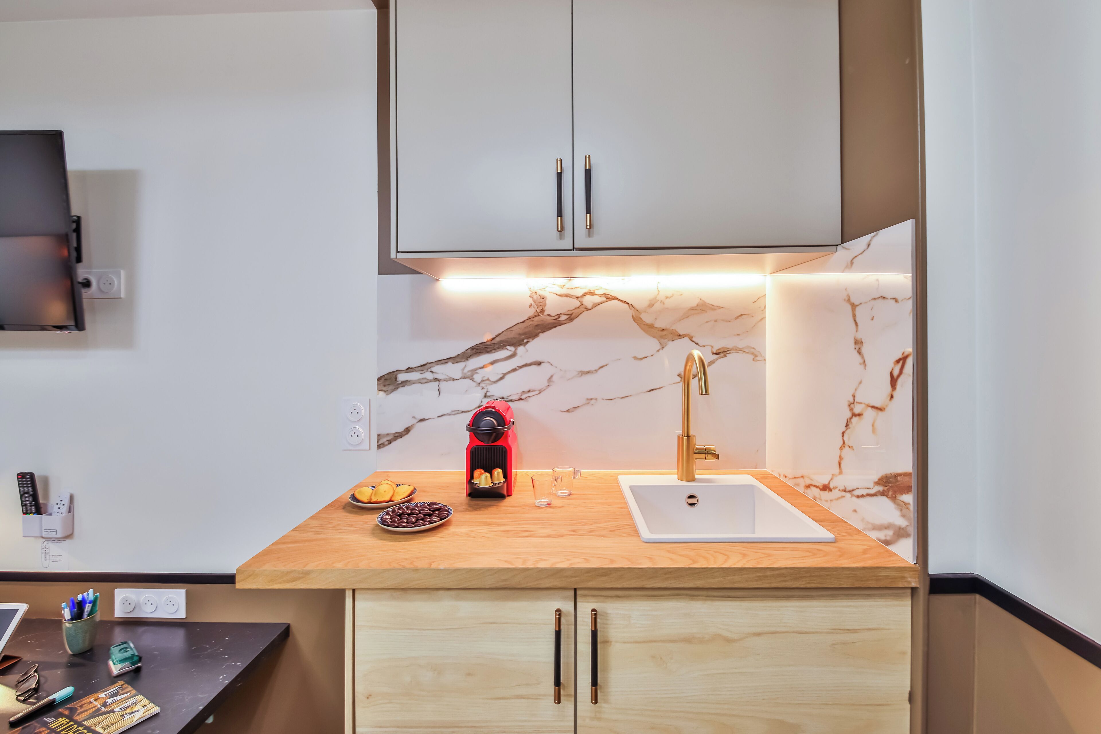 A modern kitchen with marble backsplash, wooden countertop, and built-in cabinets.