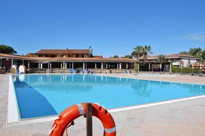 Une piscine avec des chaises longues et un cercle de sauvetage.