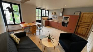 A modern living room with a sofa, a coffee table, and a dining area.