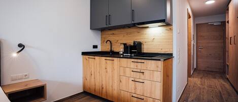 Een moderne keuken met houten kastjes, een zwart aanrecht en een ingebouwde kookplaat.