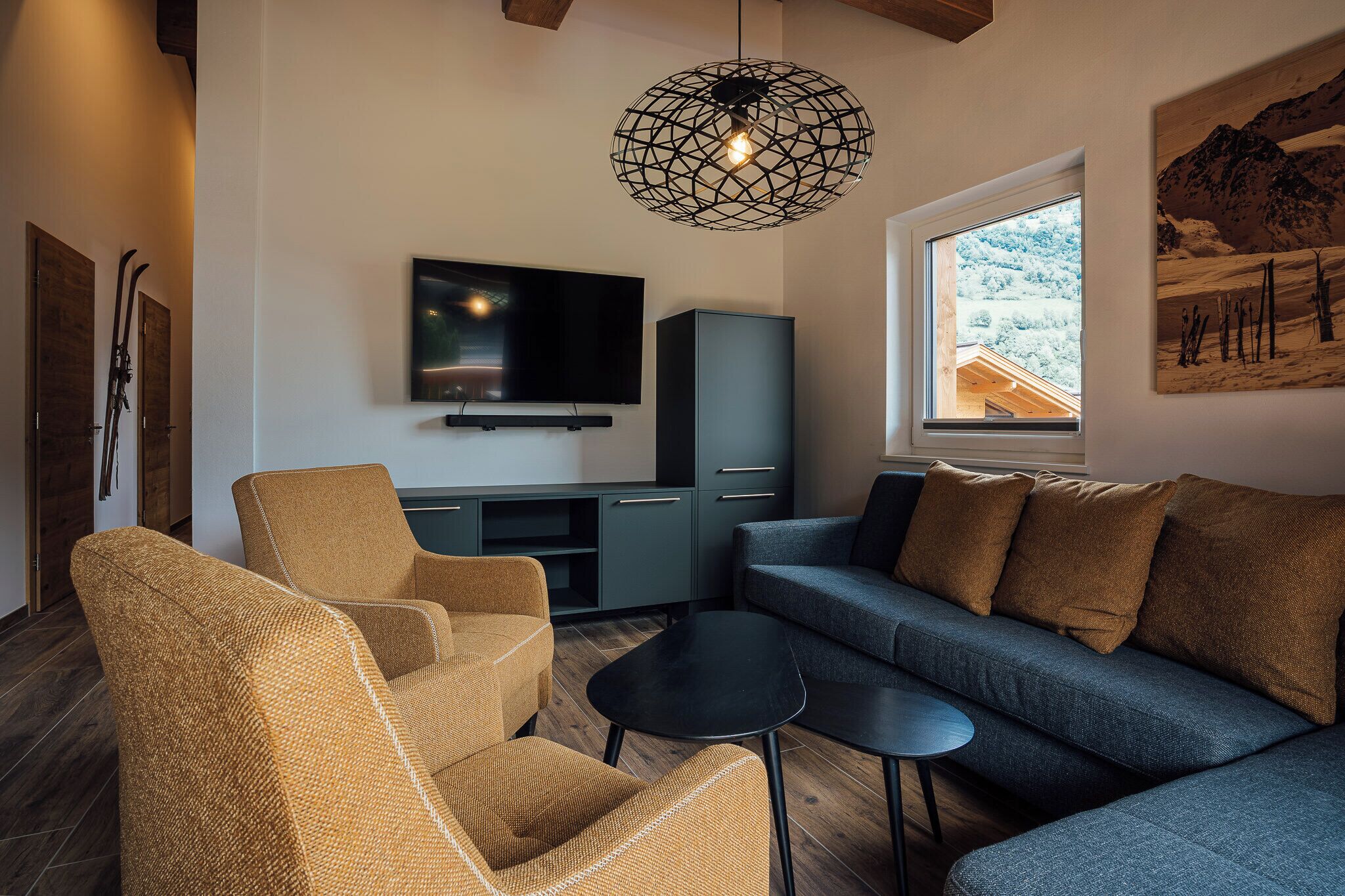 A modern living room with a television, sofa, and chairs.