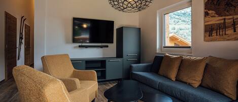A modern living room with a television, sofa, and chairs.