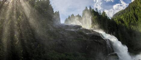 A waterfall cascading down a rocky cliff surrounded by dense forest.