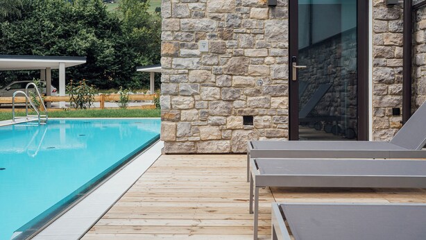A stone building with a pool and lounge chairs. - Der Kehlbachwirt by Monteviva (Niedernsill)