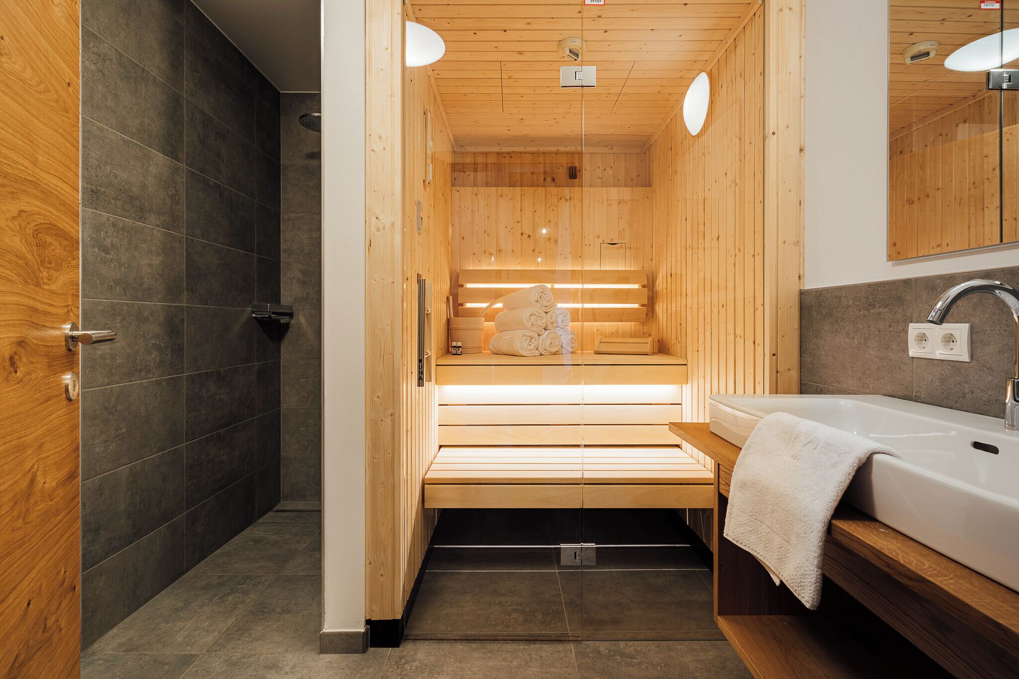 Una sauna con panche in legno e una panca con asciugamani.