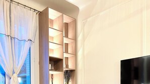 Una sala de estar moderna con un sofá, una mesa de centro, un televisor y una estantería empotrada de madera.