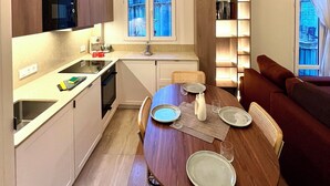 Una cocina moderna con comedor, electrodomésticos integrados y un amplio ventanal con vistas a la ciudad.