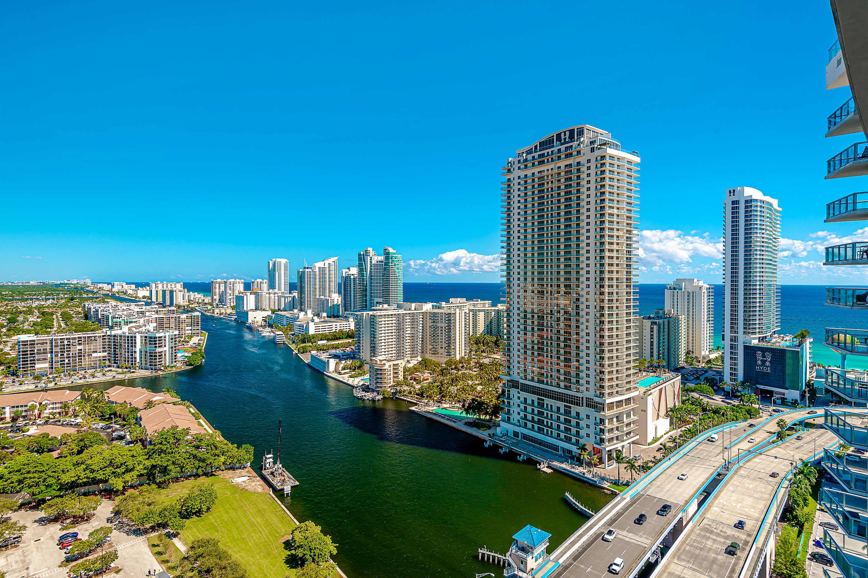 Un hotel moderno con vistas a un río y al horizonte de la ciudad.