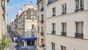 Une vue de rue avec des immeubles, une devanture de magasin bleue et un passage piéton.