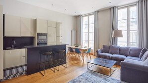 Un appartement moderne comprenant une cuisine, un coin repas et un salon.