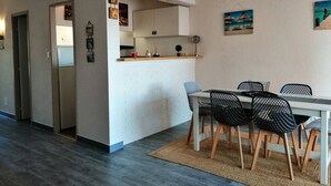 A compact living space with a kitchenette, dining area, and a small entryway.