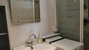 Une salle de bain avec un lavabo, un miroir et une douche.