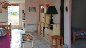 A compact living space with a kitchenette, a dining area, and a small sleeping area.