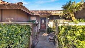 A residential property with a gated entrance, a tiled roof, and a well-maintained garden with various plants and a palm tree. - 3-bedroom Artist Oasis in the HeART of Las Vegas (Las Vegas)