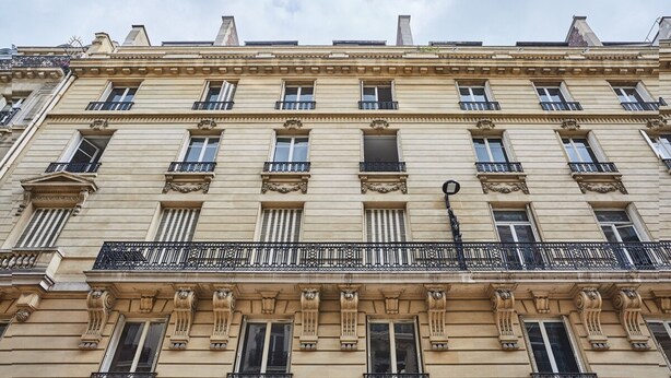 A multi-story building with classical architectural features, including ornate balconies and decorative moldings. - Superb Flat Ave Montaigne With Eiffel Tower View (Paris)