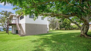 A two-story house with a covered garage and a staircase leading to a deck. - Welcome to Waterfront Views (Gympie)