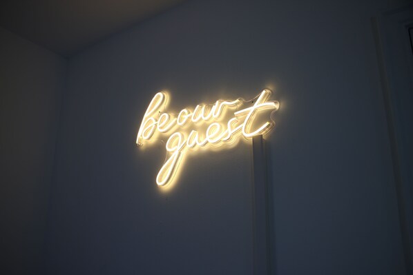 A neon sign with the word "beour guest" on a wall. - 3 Bedroom House Close to City Centre/ Free Parking (Manchester)