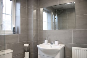 Huis | Badkamer | Een douche, een haardroger, handdoeken
